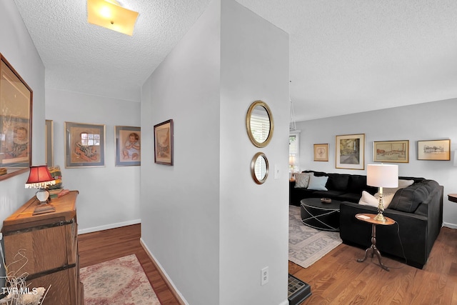 hallway featuring a textured ceiling and hardwood / wood-style flooring