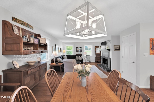 dining space with a textured ceiling, a notable chandelier, and hardwood / wood-style flooring