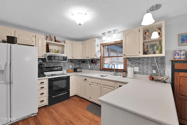 kitchen with white refrigerator with ice dispenser, light hardwood / wood-style flooring, decorative light fixtures, sink, and black / electric stove