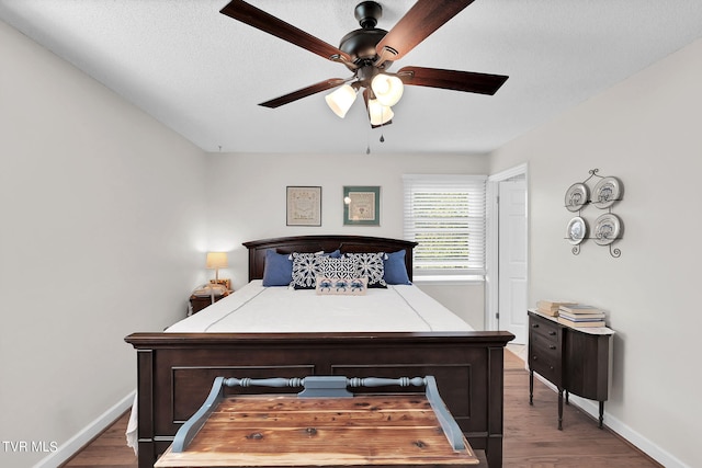 bedroom featuring a textured ceiling, ceiling fan, and wood-type flooring