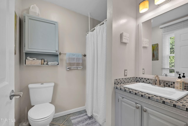 bathroom featuring tile patterned flooring, vanity, toilet, and tasteful backsplash