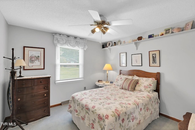 carpeted bedroom with ceiling fan and a textured ceiling