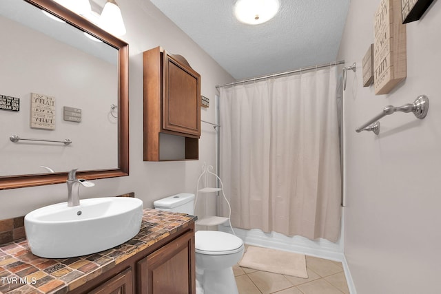 full bathroom with a textured ceiling, vanity, toilet, tile patterned floors, and shower / bath combo