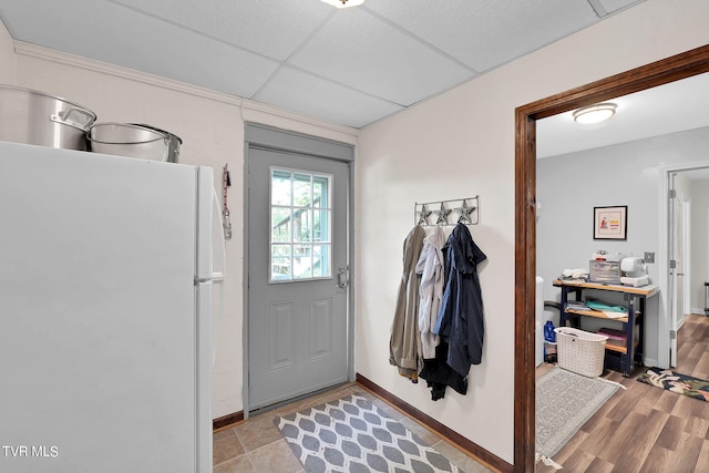 doorway to outside featuring light hardwood / wood-style flooring and a paneled ceiling