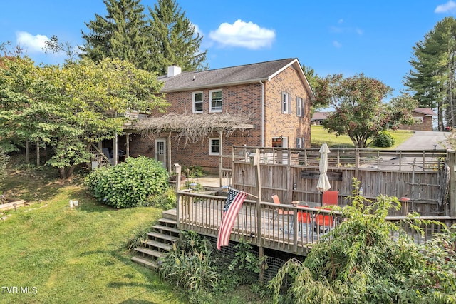 back of property with a wooden deck and a yard