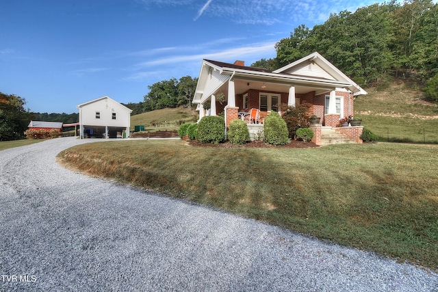 view of front facade with a front yard and covered porch