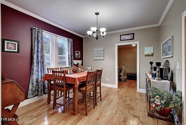 dining room featuring ornamental molding, a chandelier, and light hardwood / wood-style floors