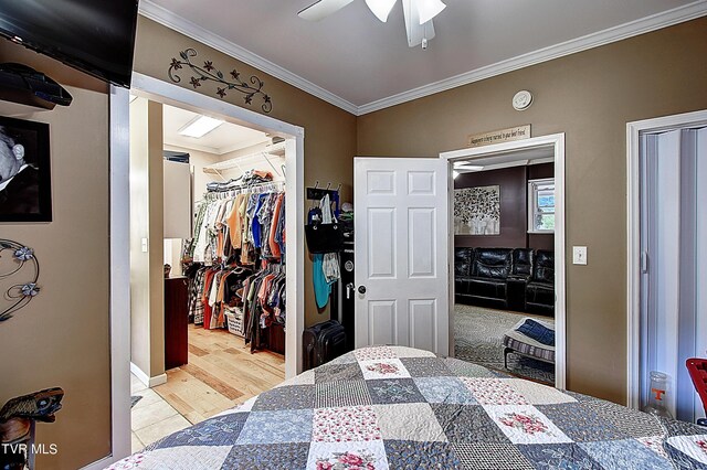 bedroom featuring ornamental molding, ceiling fan, light hardwood / wood-style flooring, and a closet