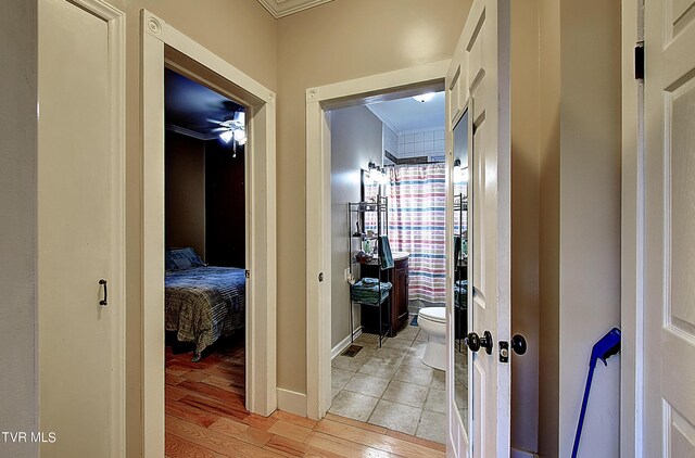 hallway featuring crown molding and light hardwood / wood-style floors