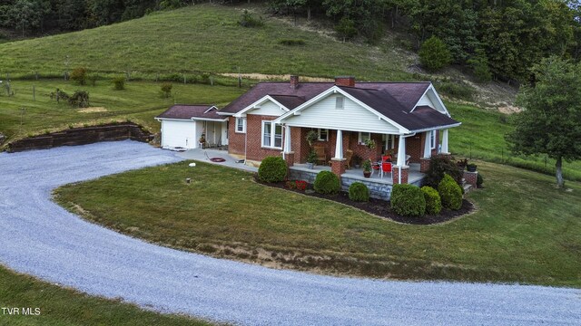 view of front of property with covered porch and a front yard