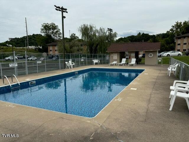 pool featuring fence and a patio