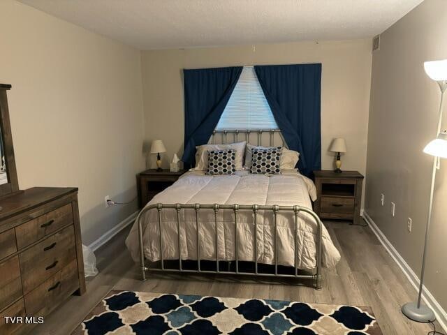 bedroom featuring baseboards and wood finished floors