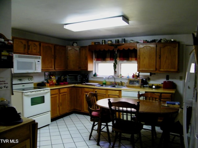 kitchen with sink, light tile patterned floors, and white appliances