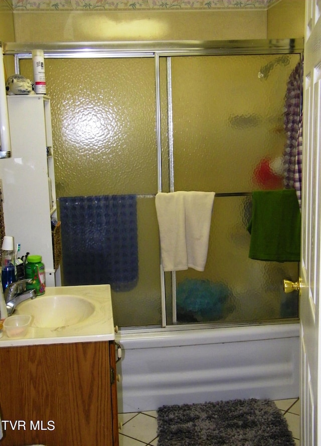 bathroom featuring tile patterned flooring, vanity, and bath / shower combo with glass door