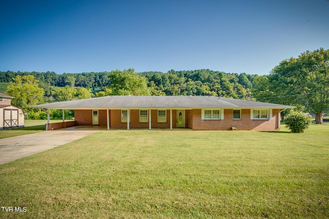 single story home featuring a front yard, a shed, and a carport