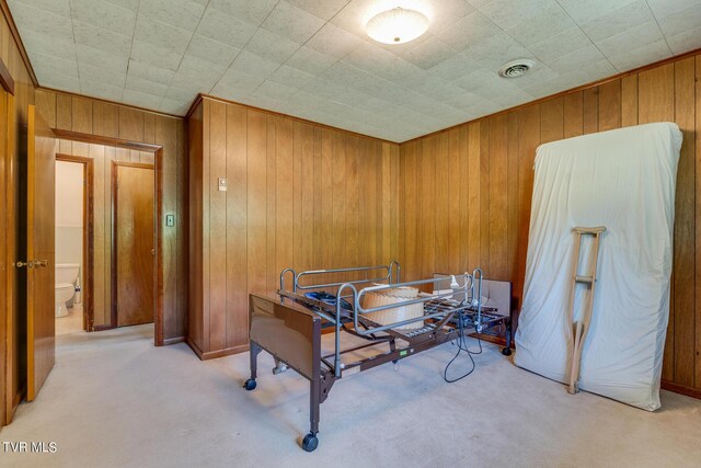 misc room featuring light colored carpet and wooden walls