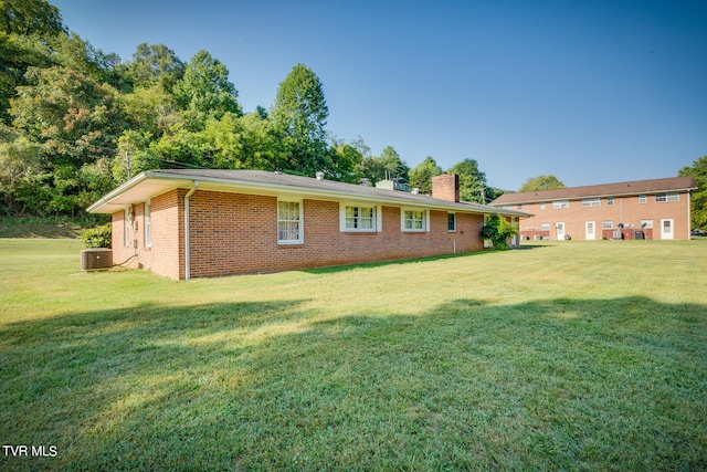 back of property featuring a yard and central air condition unit