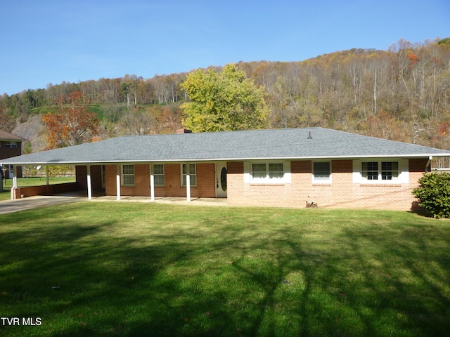 single story home with a front yard, a mountain view, and a carport