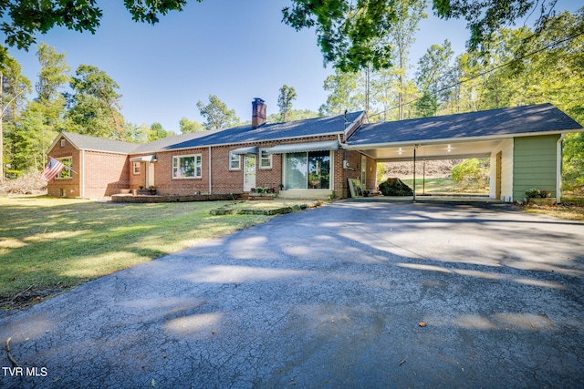 ranch-style house featuring a carport and a front lawn