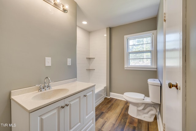 full bathroom featuring vanity, toilet, hardwood / wood-style flooring, and bathing tub / shower combination