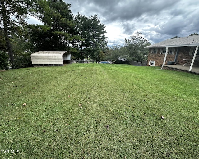 view of yard with a storage shed and a patio