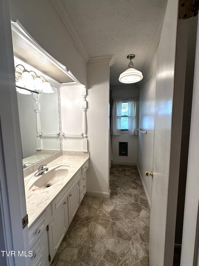 bathroom featuring a textured ceiling, vanity, and crown molding