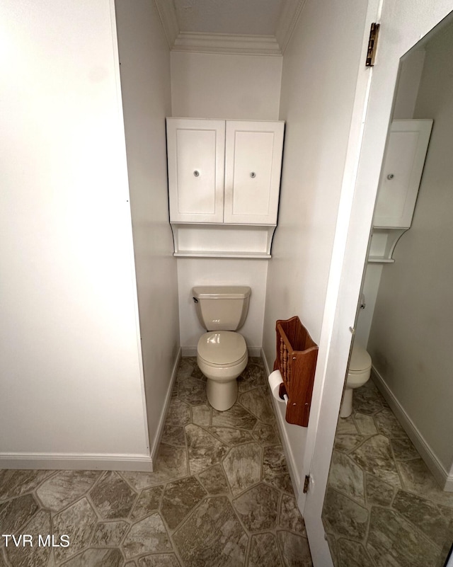 bathroom featuring ornamental molding and toilet