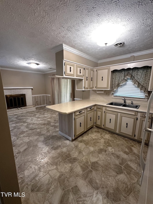 kitchen featuring a textured ceiling, crown molding, kitchen peninsula, and sink