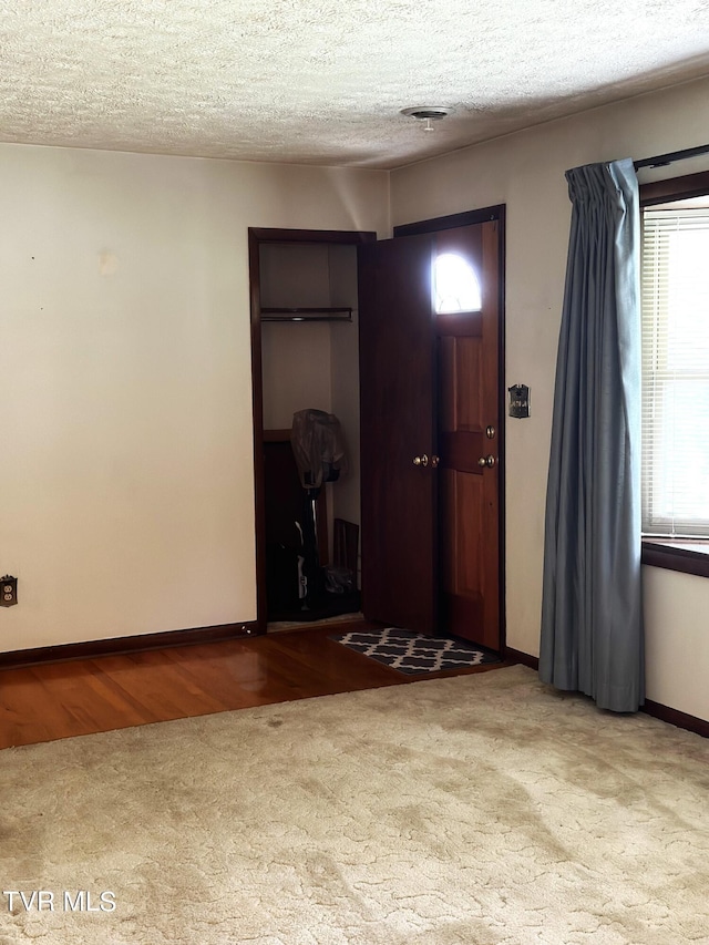 foyer entrance with light hardwood / wood-style flooring and a textured ceiling