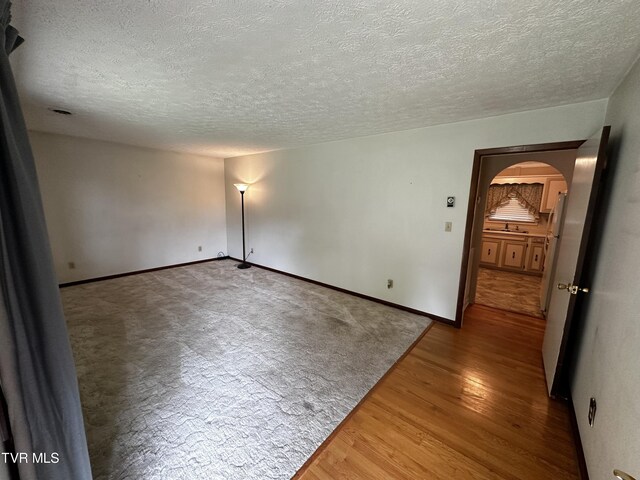 empty room featuring a textured ceiling and hardwood / wood-style flooring