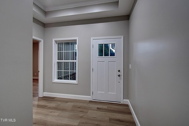 entryway with ornamental molding and light hardwood / wood-style flooring