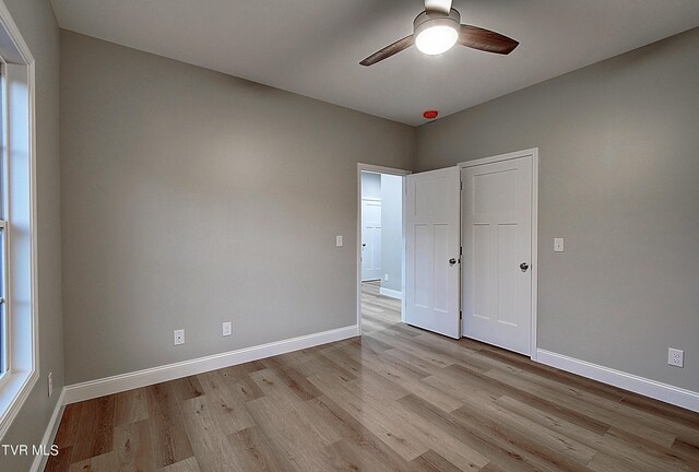 empty room with light hardwood / wood-style flooring and ceiling fan