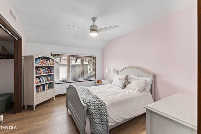 bedroom featuring hardwood / wood-style floors, vaulted ceiling, and ceiling fan