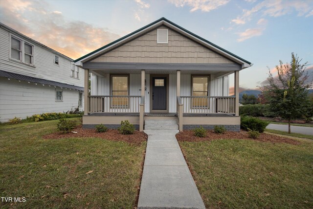 bungalow with a yard and covered porch