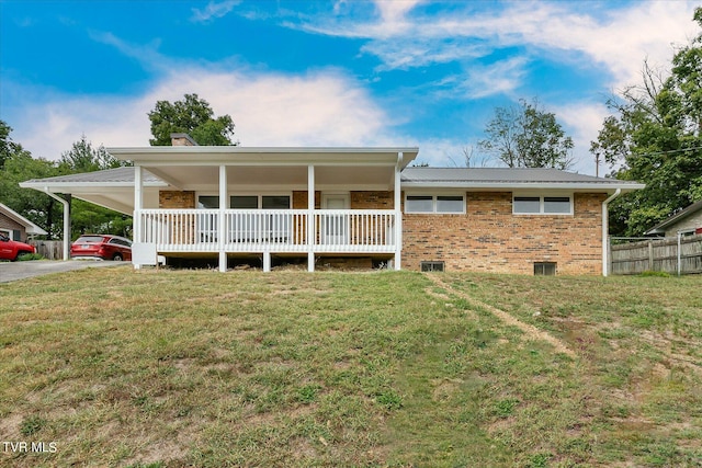 view of front facade with a front lawn, a carport, and covered porch