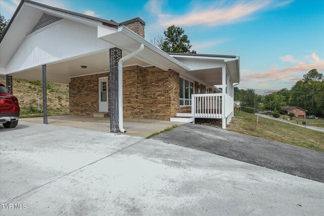 view of side of home featuring a carport and covered porch