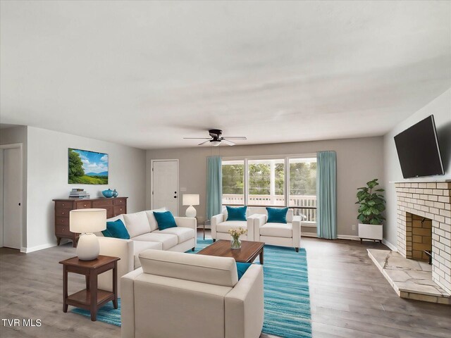 living room featuring ceiling fan, hardwood / wood-style floors, and a fireplace