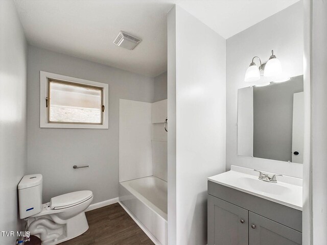 full bathroom with vanity, toilet, hardwood / wood-style flooring, and shower / bathing tub combination