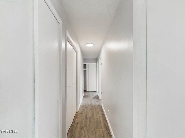 hallway with hardwood / wood-style floors