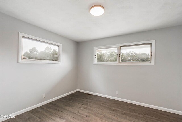 spare room with dark hardwood / wood-style flooring