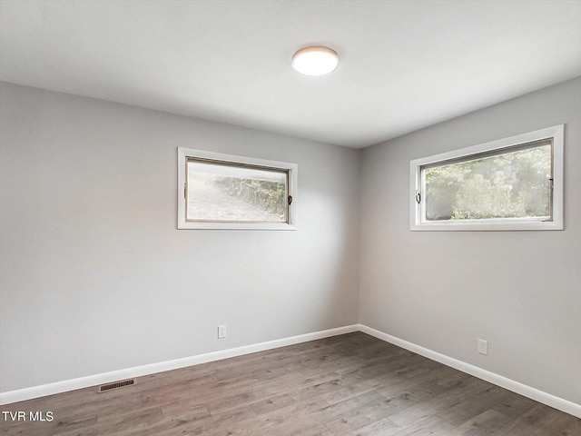 empty room featuring a healthy amount of sunlight and hardwood / wood-style flooring