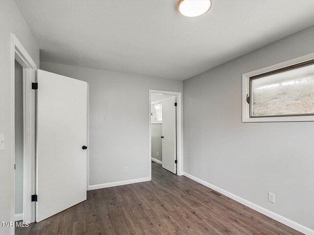 unfurnished bedroom with dark hardwood / wood-style floors