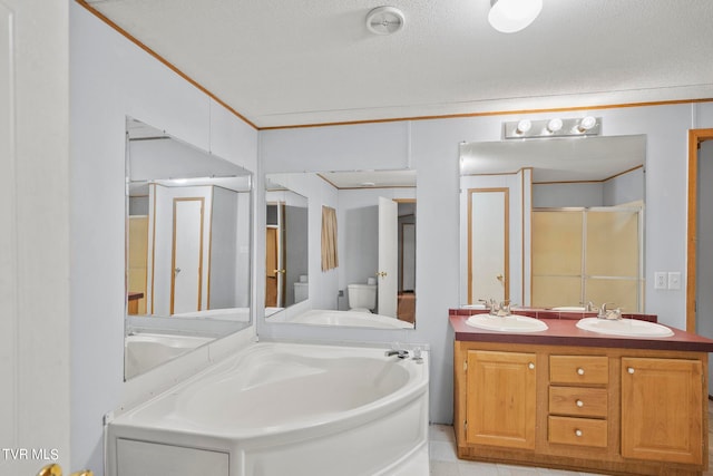 bathroom with a tub to relax in, vanity, a textured ceiling, toilet, and ornamental molding