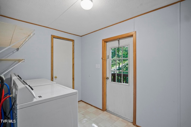 clothes washing area featuring crown molding, a textured ceiling, and washing machine and dryer