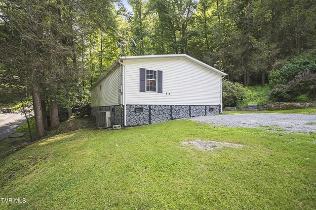 view of side of home featuring central AC and a lawn