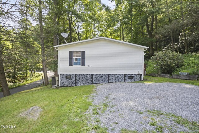 view of side of home featuring a yard and cooling unit