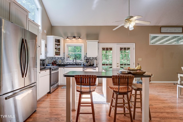 kitchen with stainless steel appliances, light hardwood / wood-style floors, white cabinetry, sink, and ceiling fan