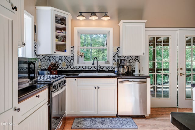 kitchen featuring a healthy amount of sunlight, stainless steel appliances, sink, and white cabinetry