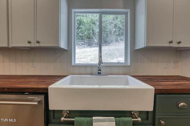 kitchen with plenty of natural light, sink, white cabinetry, and wood counters