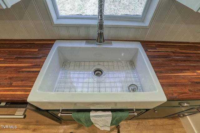 details featuring sink, wooden walls, and a skylight